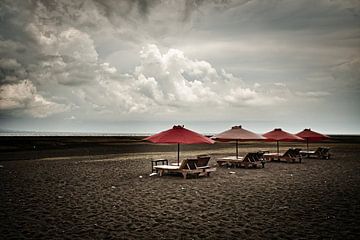 Verlaten ligstoelen onder een dreigende hemel
