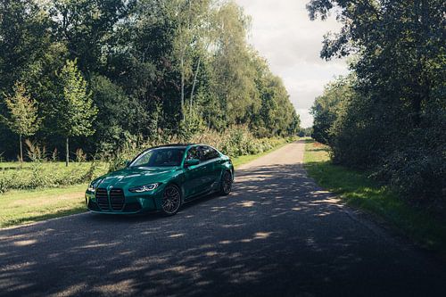 Groene BMW M3 G80 in een rustgevende, bosrijke omgeving