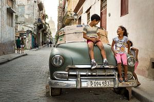 Kinderen spelen op een Cubaanse auto van Paula Romein