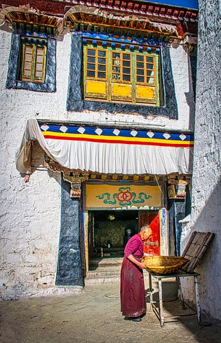 Monnik aan het werk op de binnenplaats van het klooster, Tibet