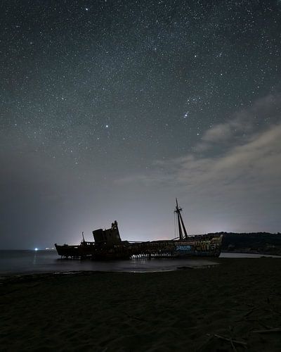 Schipwrak onder sterrenhemel bij nacht