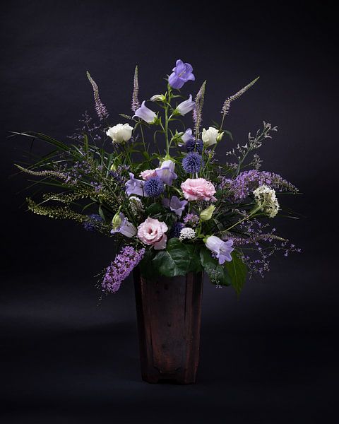 Ein Blumenstrauß aus lila, rosa und weißen Blumen in einer alten Vase von Marjolijn van den Berg