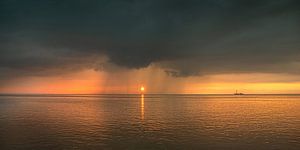 Sonnenuntergang über dem Wattenmeer hinter einem kleinen Regenschauer