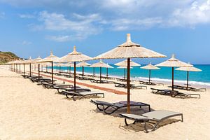 Strohsonnenschirme für Schatten in einer Reihe an der Küste von Kefalonia in Griechenland
