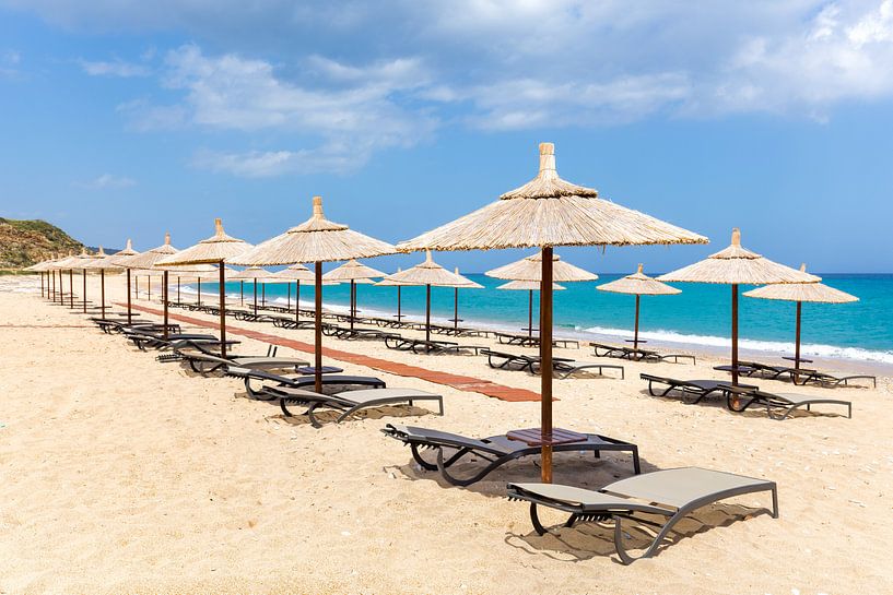 Many reed beach umbrellas in a row  on beach at greek sea by Ben Schonewille
