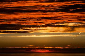 des nuages rouges au bord de la mer sur Anita Hermans