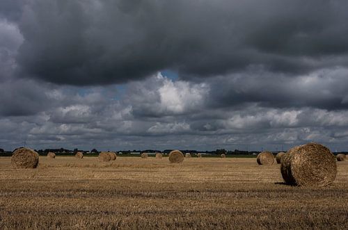 Straw rolls in a field with beautiful clouds