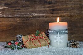 Burning candle with christmas gift and decoration by Alex Winter