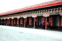 Tibetanen draaien aan gebedswielen in tempel