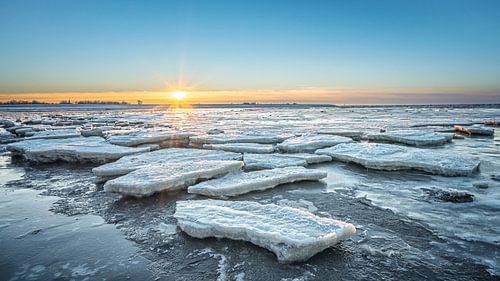 Ijsschotsen op de Waddenzee tijdens zonsondergang