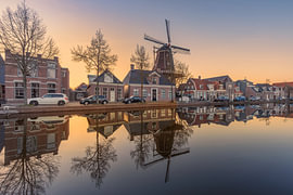 Molen de Vlijt weerspiegelt in de gracht van Meppel tijdens zonsondergang
