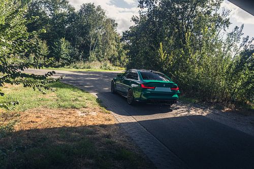 Groene BMW M3 G80 in een rustgevende, bosrijke omgeving