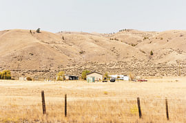 A secluded ranch set against the golden hills of the Canadian outback by Tom Tewes