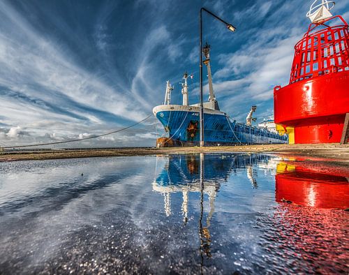 De haven van Harlingen, Friesland, met weerspiegeling in een plas.