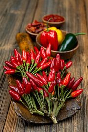 Des piments rouges ardents sur une table en bois rustique sur Photo Art Thomas Klee