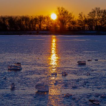 Stuk ijs op een bevroren meer tijdens een warme zonsopkomst van Kim Willems