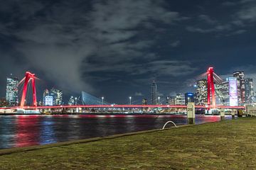 Uitzicht op de rode Willemsbrug in de avond met prachtige wolken