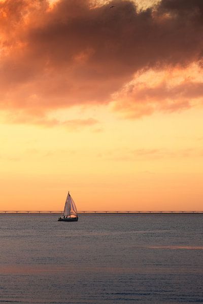 Segelboot gegen einen orangefarbenen bewölkten Himmel von Sugar_bee_photography
