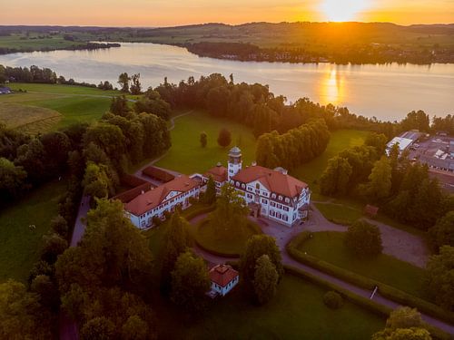 Luftbild bei Sonnenaufgang mit Schloß und Riegsee im Hintergrund