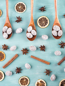 Spiced almonds with anise stars and cinnamon on blue background