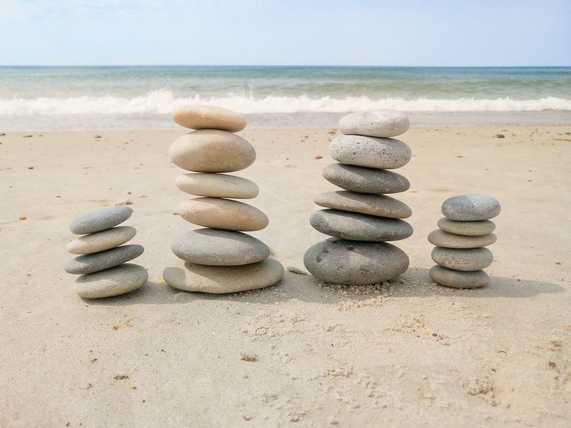 Piles of stones on the beach by Linda Schellevis