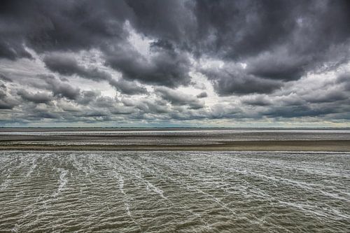 Wolkenlucht boven het Wad bij eb