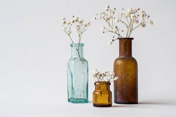 Drei antike Vasen auf weißem Hintergrund mit Zweigen getrockneter Gypsophilia. Minimalistisches Bild von Marjolein Hameleers