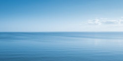 Een eindeloos Hollands waterlandschap met een wolk aan de horizon