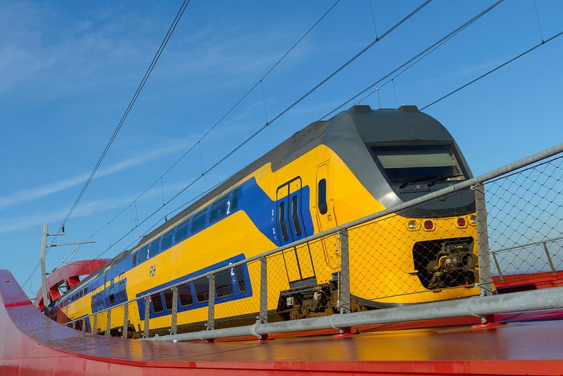 Train driving over a red modern design bridge by Sjoerd van der Wal Photography