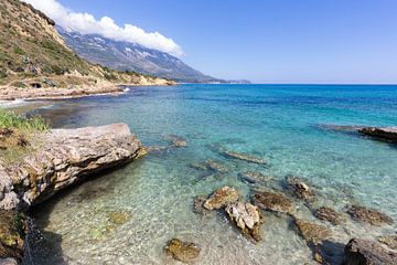 Kust met blauwe zee, rotsen en bergen in Griekenland van Ben Schonewille