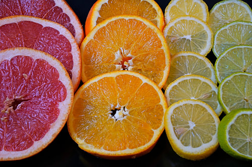 Citrusvruchten in plakjes gesneden en op een zwarte serveerplank gelegd