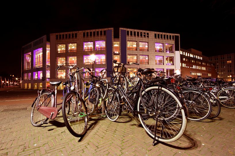 Cycling in front of the concert hall in Amsterdam Netherlands at night by Eye on You