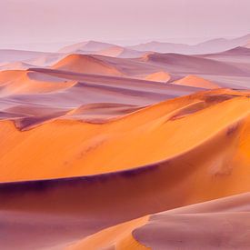 Foto van een woestijnlandschap met zandduinen bij zonsopkomst van Chris Stenger