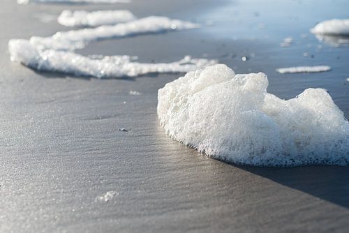 Schuimende golven op het strand