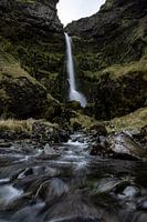 Waterval tussen ruige rotsen in IJsland