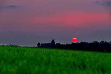 spectaculaire rode zonsondergang met een rode bal van vuur als de de zon