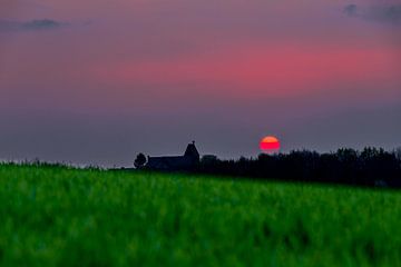 spectaculaire rode zonsondergang met een rode bal van vuur als de de zon van Kim Willems