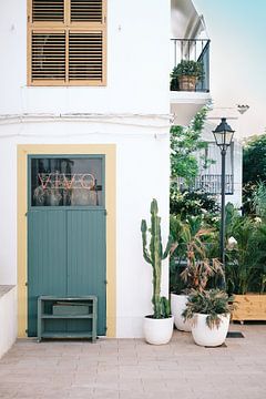 Wit huis met geel raam en groene deur op Ibiza