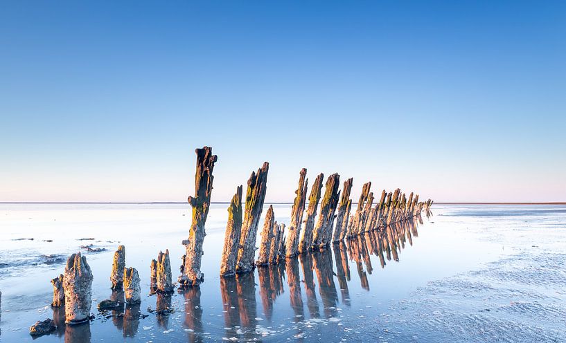 Reflectie van de paaltjes op de Waddenzee nabij Moddergat van Martijn van Dellen