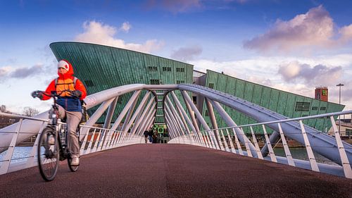 Fietser op de verbindingsbrug voor Nemo science museum in Amsterdam