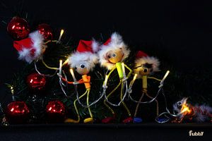 Fubby accroche des guirlandes de Noël dans l'arbre de Noël.