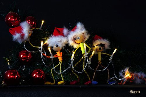 Fubby die Kerstverlichting in de Kerstboom hangen.