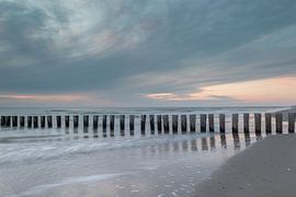 Wooden breakwaters on the tranquil coast of Ameland at dusk