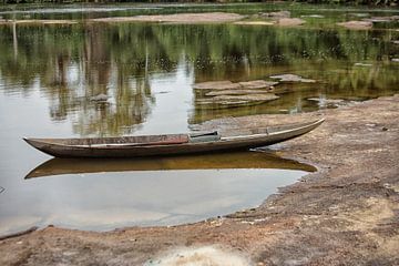 Houten kano aangemeerd op een rivier in Suriname van Patricia Hofmeester
