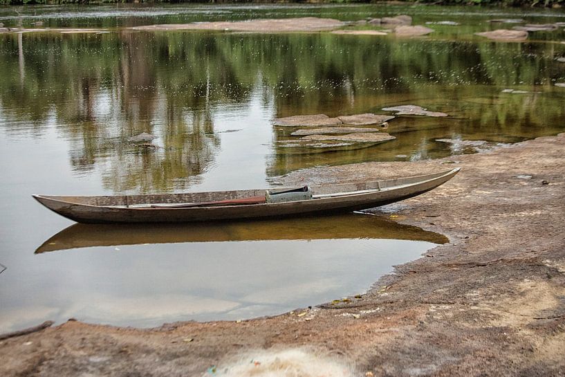 Houten kano aangemeerd op een rivier in Suriname van Patricia Hofmeester