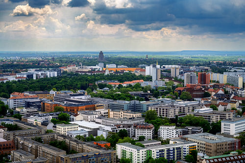 Leipzig im weiten Stadtpanorama unter Gewitterwolken