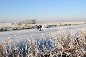 Niederländische Winterlandschaft mit Segelboot und zwei Schlittschuhläufern von Merijn van der Vliet