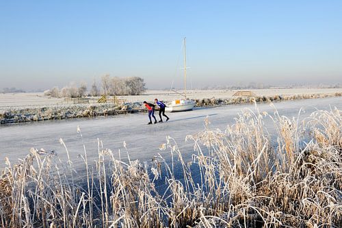 Niederländische Winterlandschaft mit Segelboot und zwei Schlittschuhläufern von Merijn van der Vliet