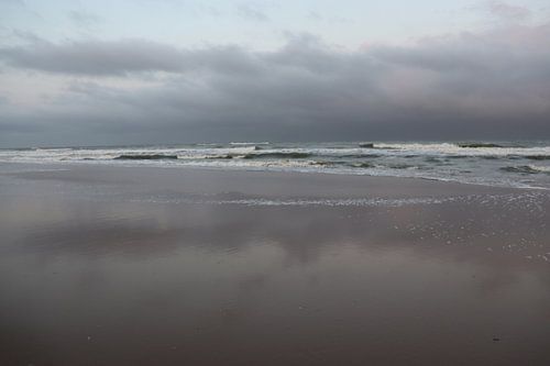 Wolken über ruhiger See zu Beginn eines grauen Tages