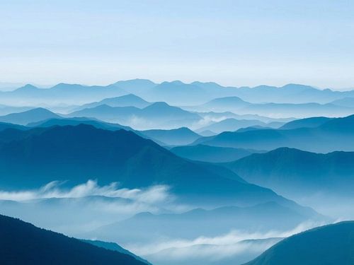 Fluisteringen van de Blauwe Pieken: Een serene reis door mistige berghorizonten